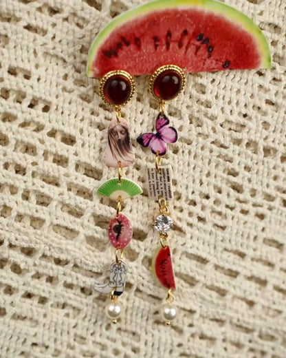 Vintage-inspired asymmetric drop earrings with purple butterfly and crystal accents, ruby-red cabochon stud