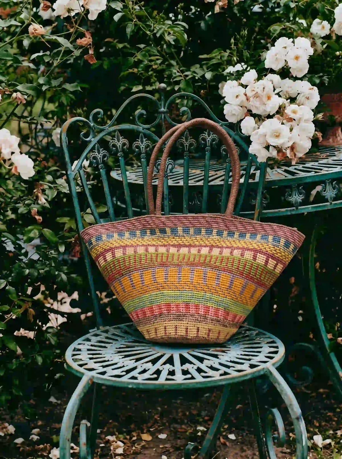 Oversized multicolor striped handwoven raffia tote bag with geometric tribal pattern and structured fan silhouette, artisan boho chic summer handbag