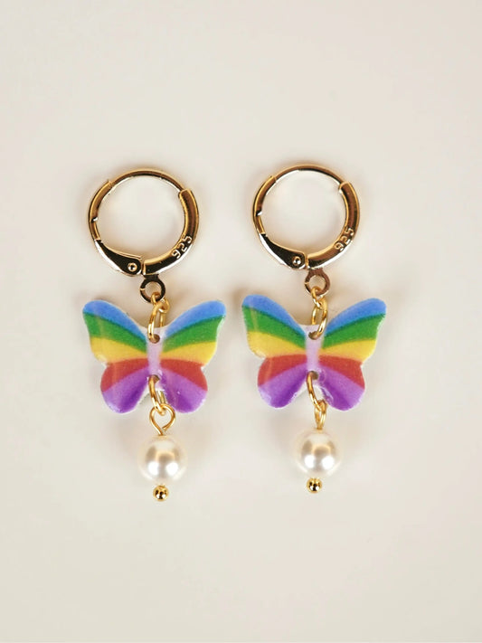 Rainbow butterfly charm hoop earrings with pearl drop and gold huggie hoops on white background