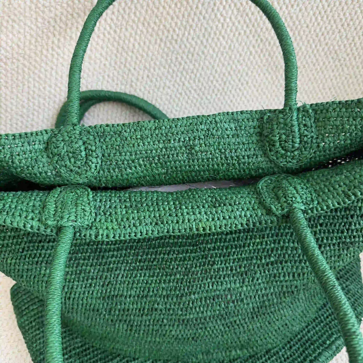 Close-up of handwoven green raffia handbag showing artisan crochet craftsmanship and natural fiber detail