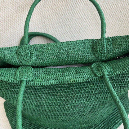 Close-up of handwoven green raffia handbag showing artisan crochet craftsmanship and natural fiber detail