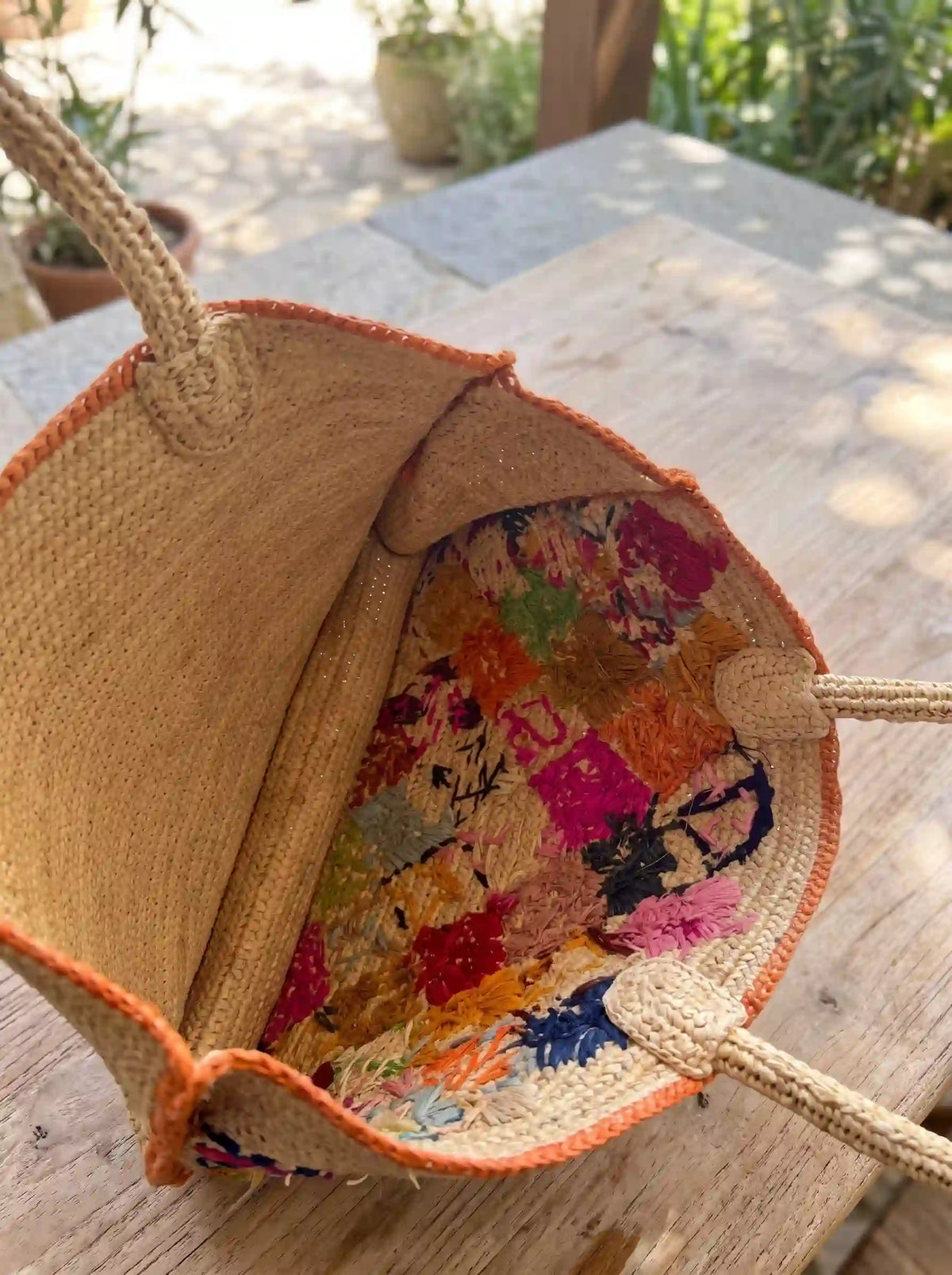 Interior view of handwoven raffia tote bag – colorful embroidered lining detail – natural fiber artisan craftsmanship close-up